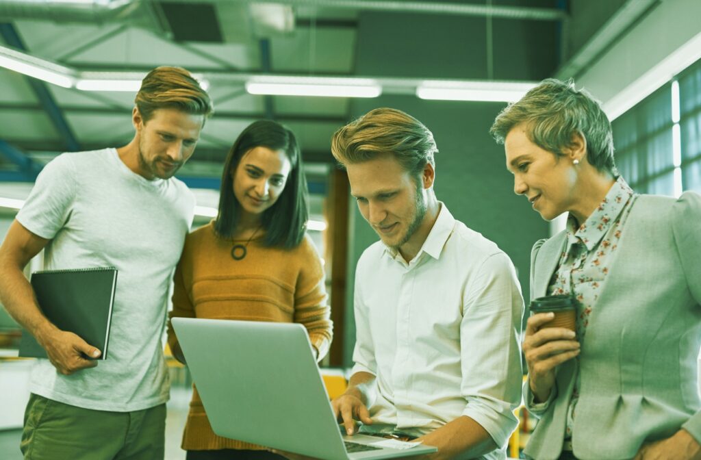 Equipe com homens e mulheres analisando a automatização de processos com a plataforma Mendix low-code.